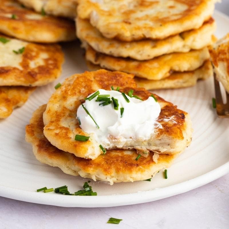 Potato Cakes with a bite taken our and sour cream on top