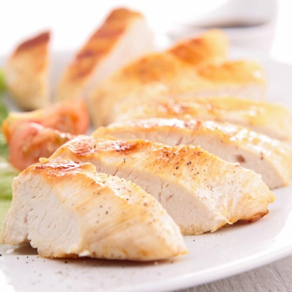 Sliced Baked Chicken Breast on a White Plate