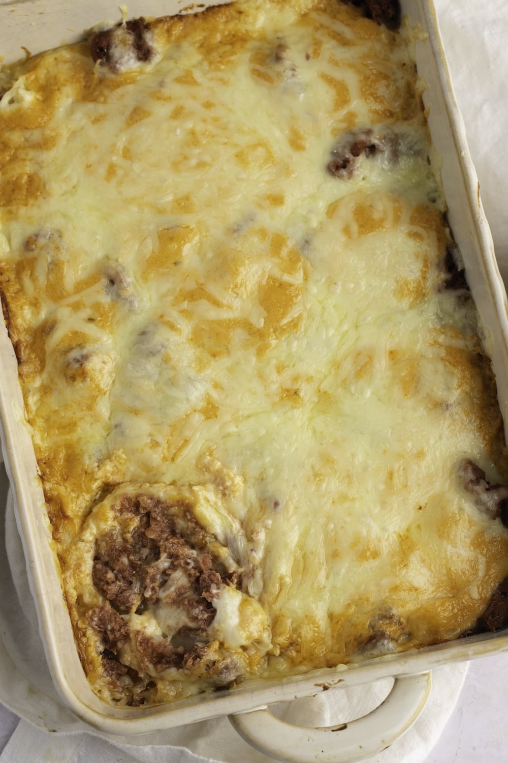 Reuben dip in a casserole dish with meat and cheese.