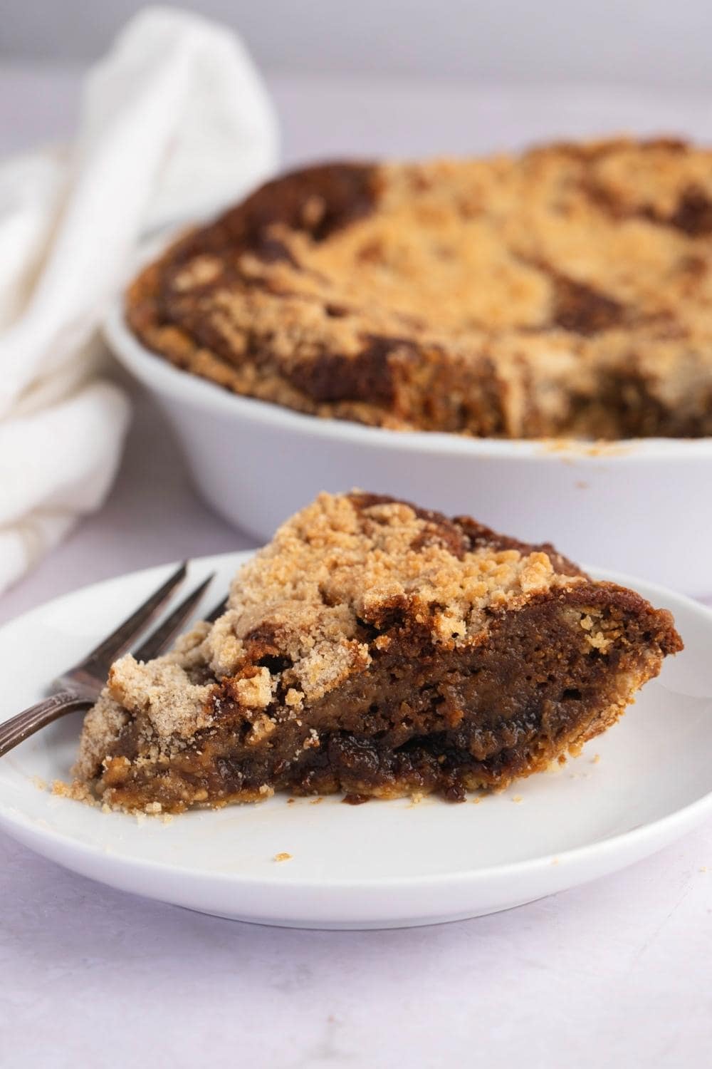 A serving of Gooey Shoofly Pie with molasses filling and crumbly toppings.