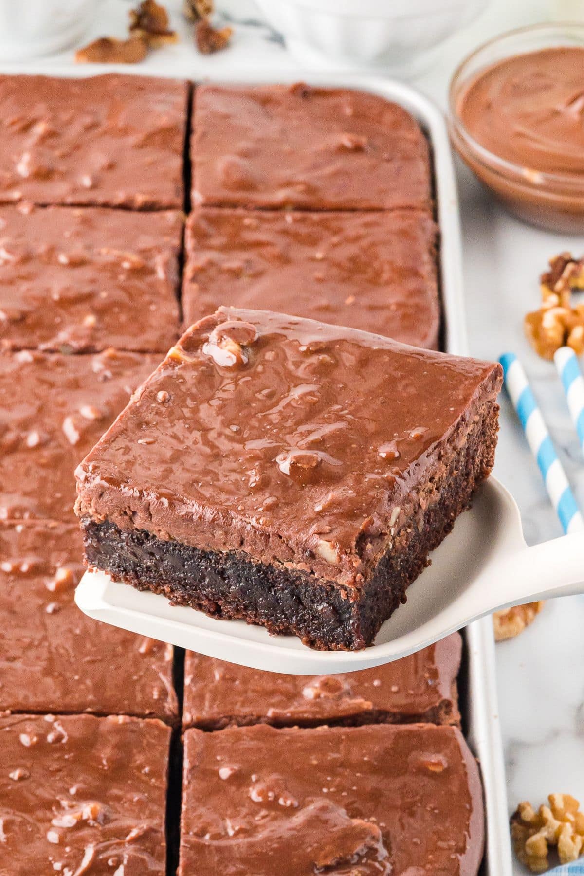Ladle lifting a square slice of Texas sheet cake. 