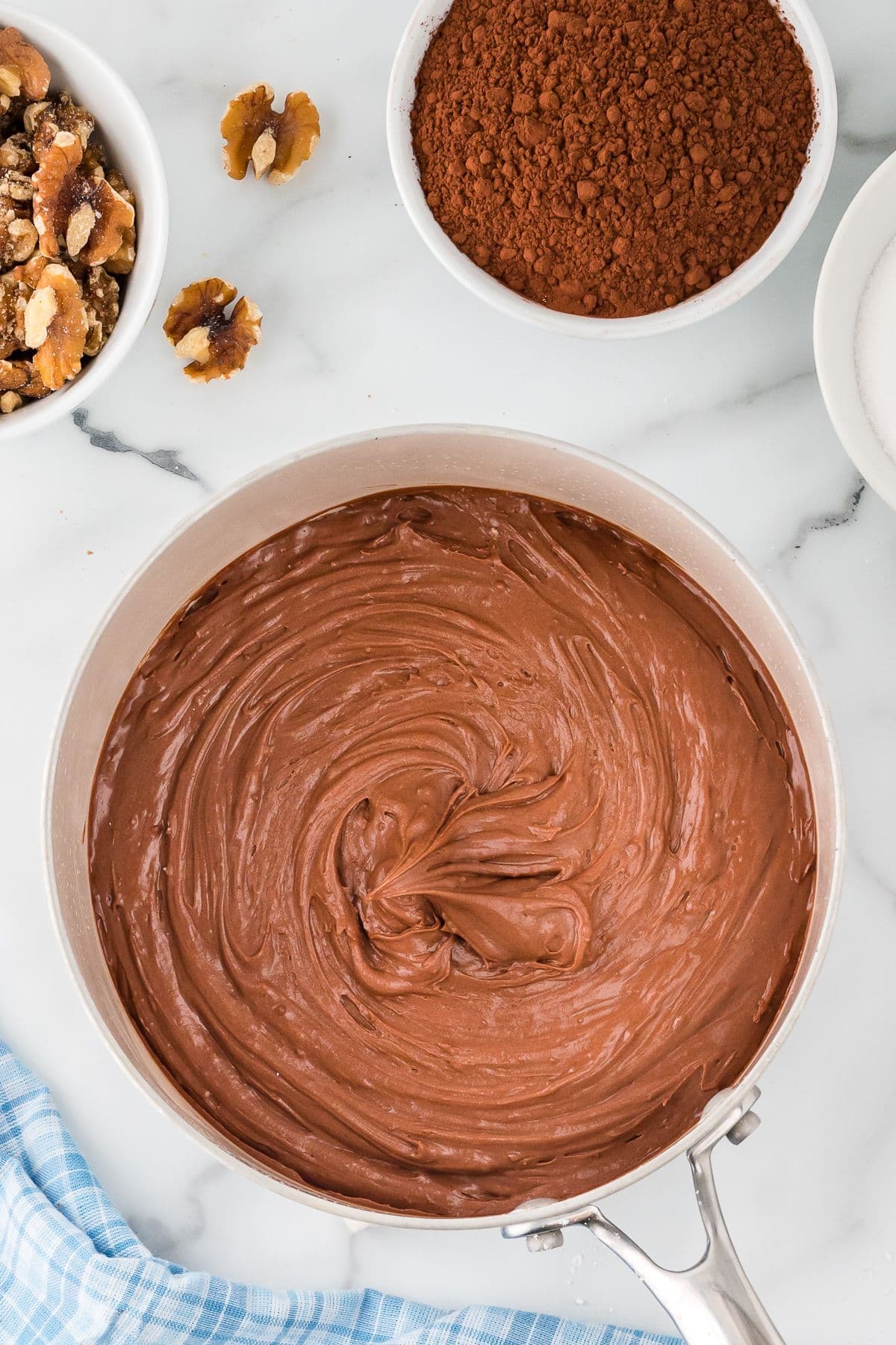 Chocolate icing in a white saucepan.