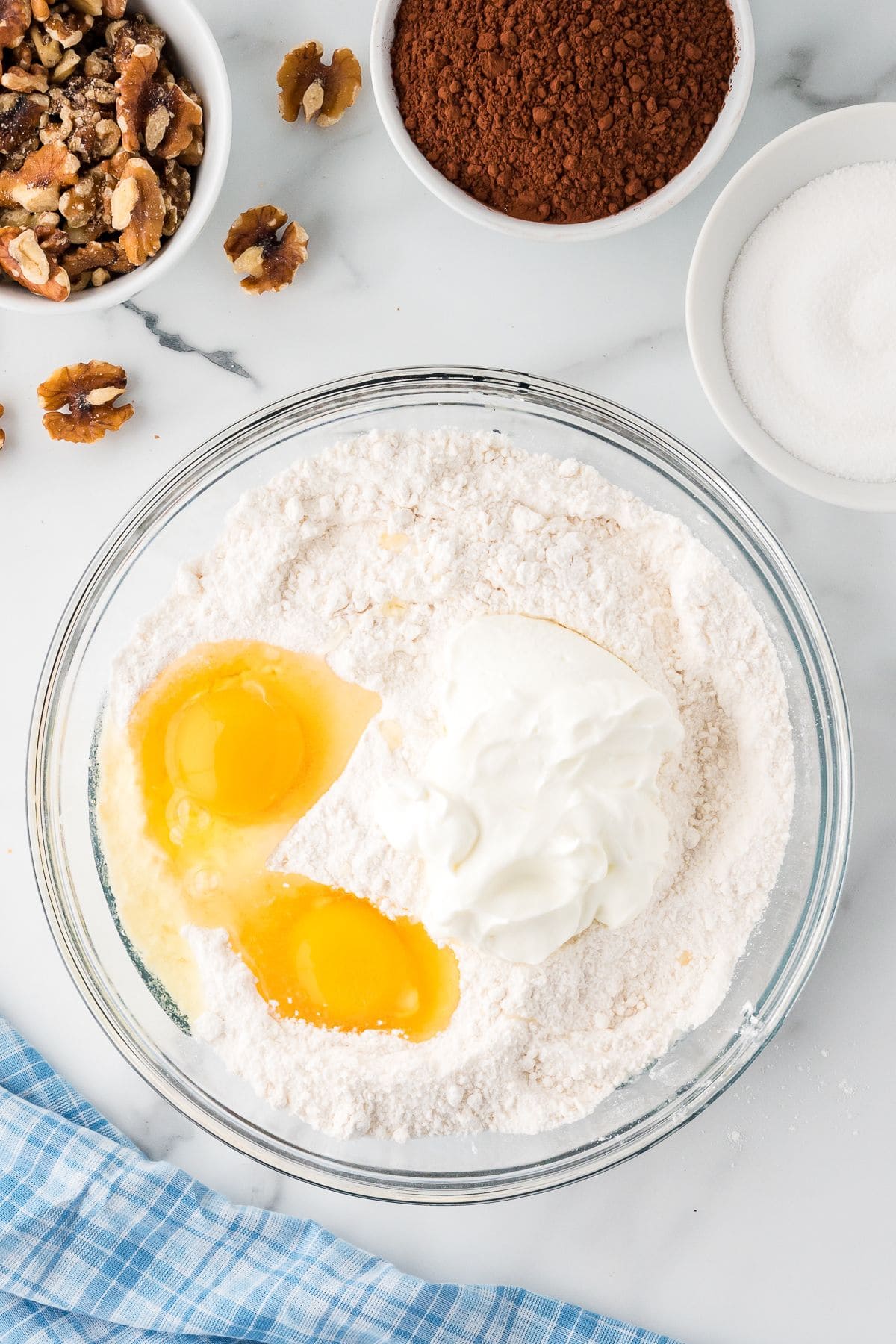 Combined flour, salt baking soda with two eggs in a glass mixing bowl.