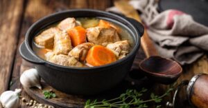 Warm Pork Soup with Carrots in a Black Bowl