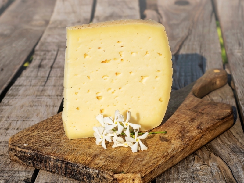 Asiago Cheese Portion on a Wooden Chopping Board