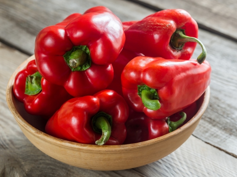Red Bell Peppers on a Wooden Bowl