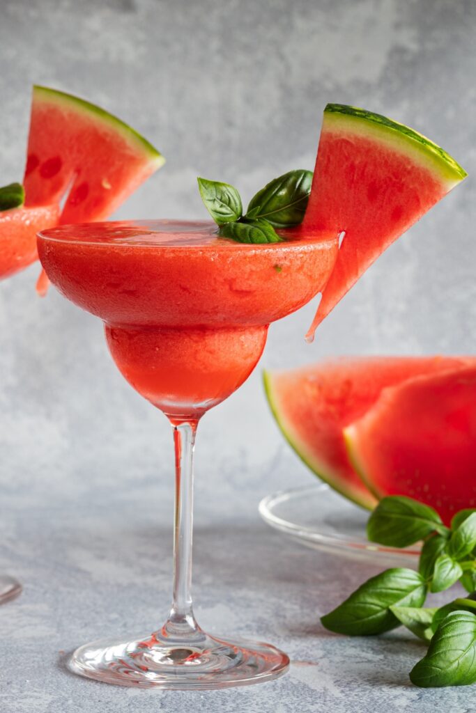 Fresh watermelon cocktail with vodka, watermelon slices, and fresh basil