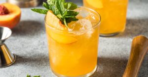 Cold Boozy Peach Smash Cocktail with Vodka and Mint