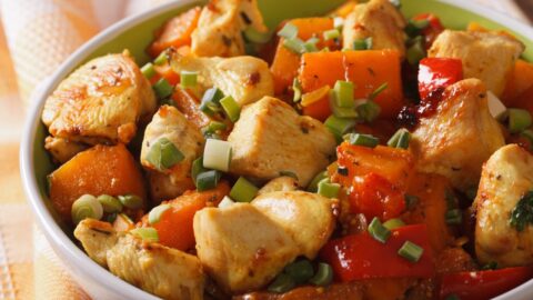 Homemade Braised Chicken Curry with Onions, Carrots and Tomatoes in a White Bowl