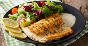 Homemade Grilled Arctic Char Fillet with Mixed Salad and Lemons