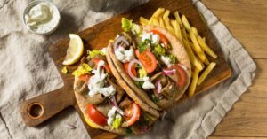 Homemade Gyros Sandwich with Tatziki, Fries, Tomatoes and Lettuce