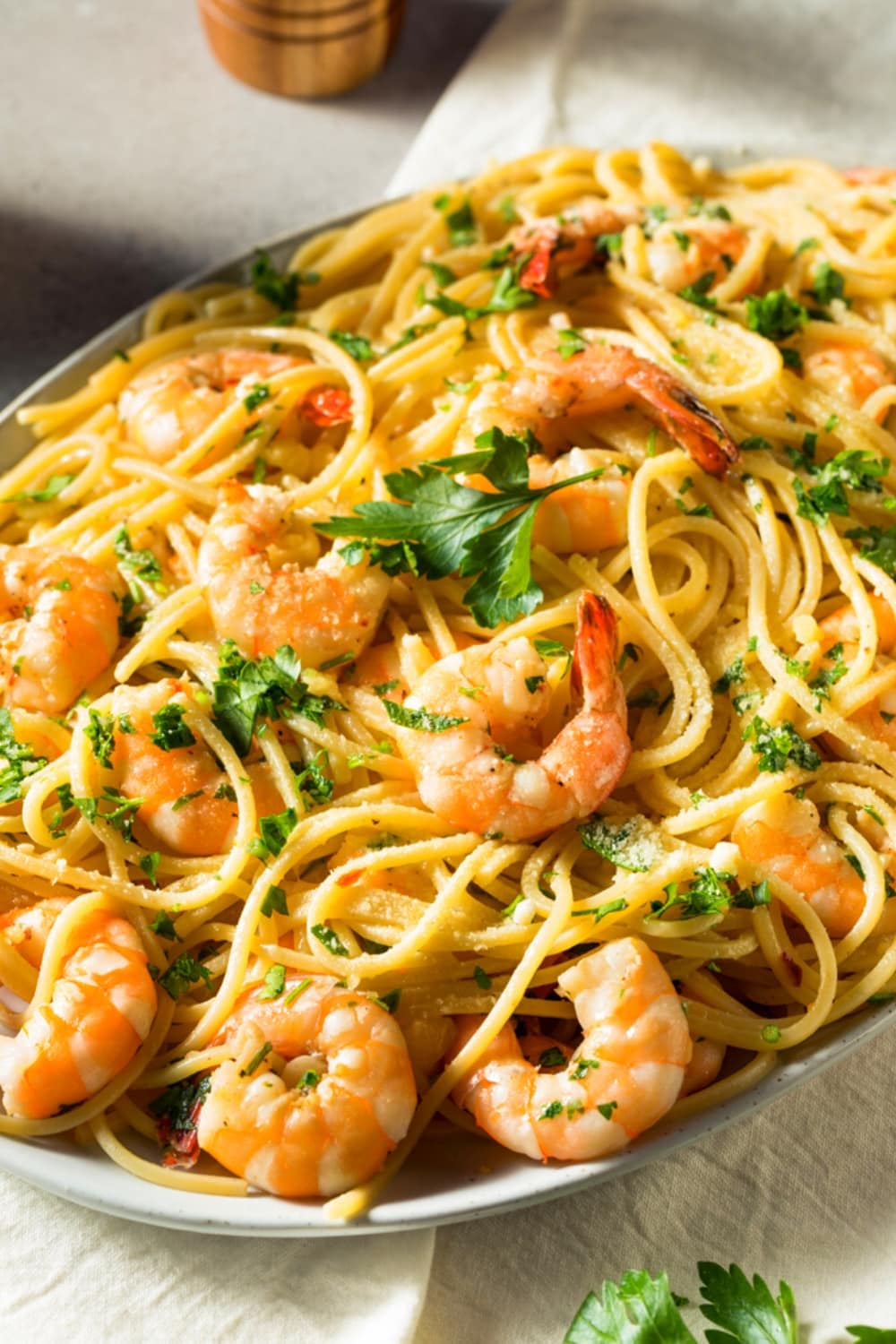 Noodles with Shrimp Scampi garnished with chopped parsley leaves.