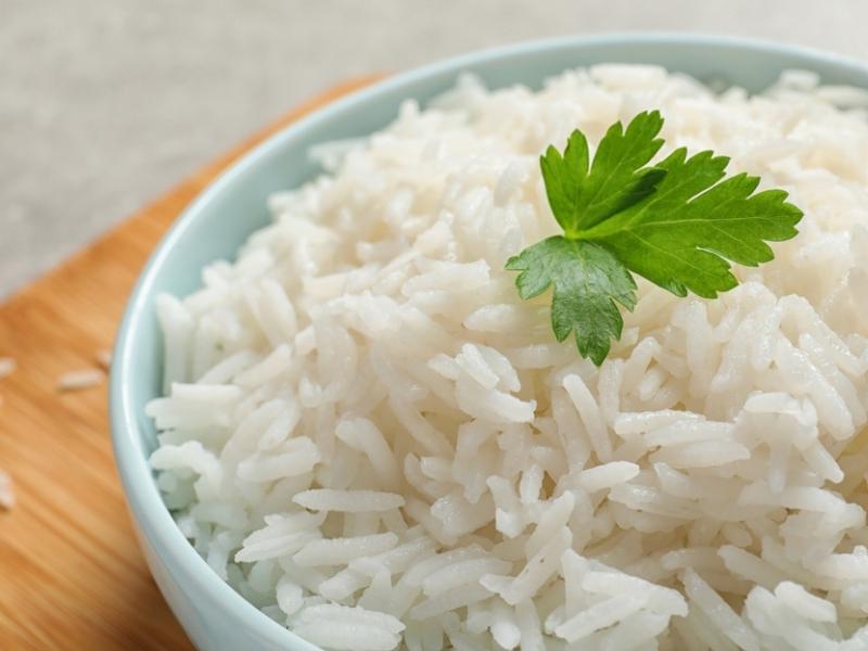 Cooked Long Grain White Rice on a Green Bowl Topped with Parsley Leaf