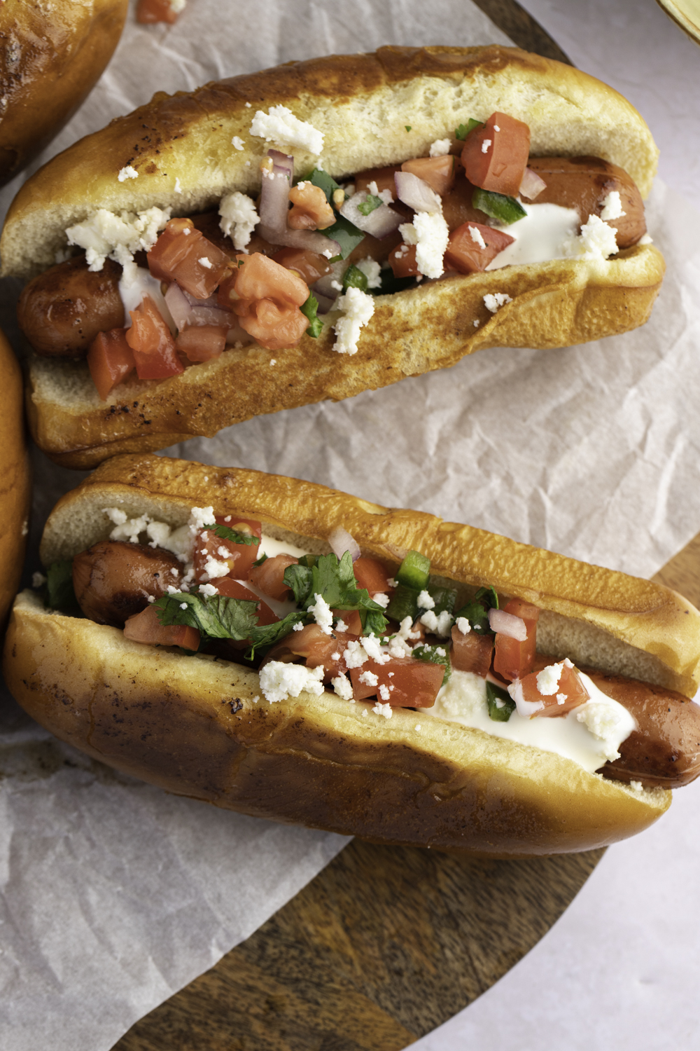 Hot dog sandwich with tomato salad toppings. 