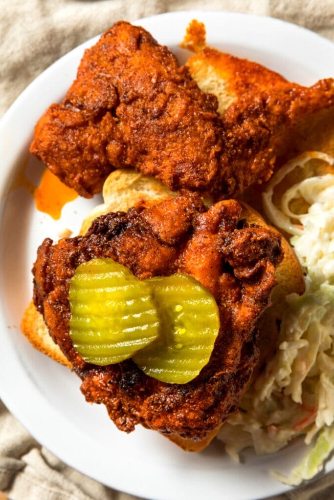 Nashville Hot Chicken Sandwich served with coleslaw topped with sliced ​​pickles