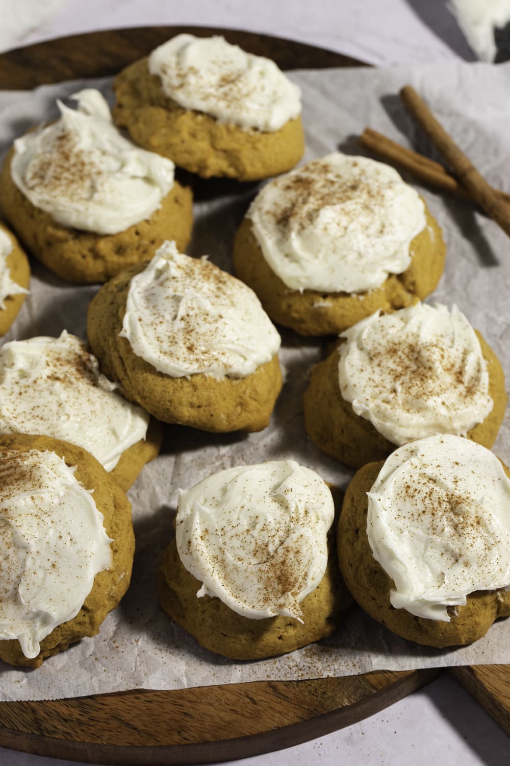 Pumpkin Cookies with Cream Cheese Frosting on a Wooden Chopping Board