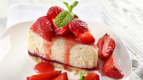 Sliced Homemade Strawberry Cheesecake in a White Plate