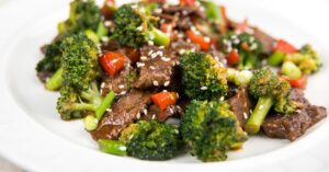 Beef and Broccoli with Sesame Seeds in a White Plate