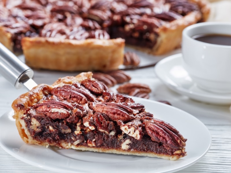 Pecan Pie Slice Served on a White Plate with Black Coffee