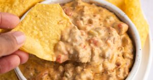 Cheesy Rotel Dip with Chips in a White Bowl