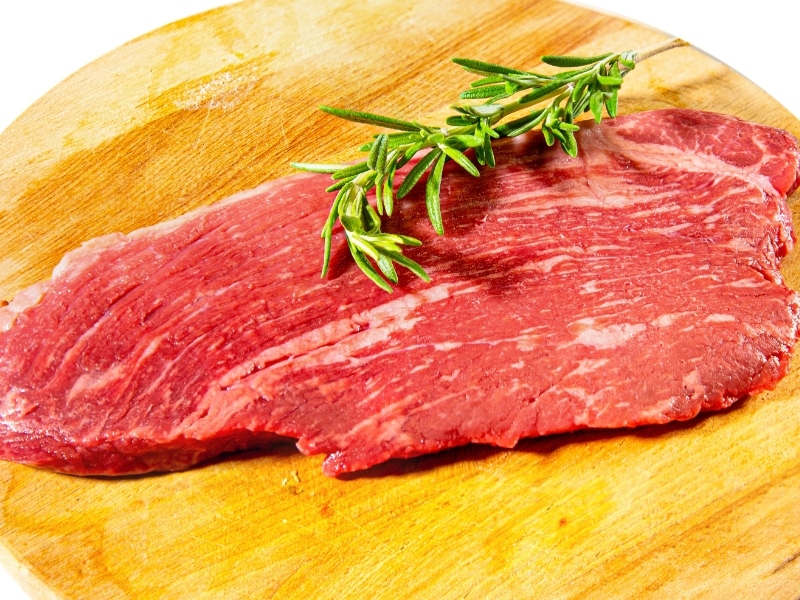 Raw Coulotte Steak on a Wooden Cutting Board with Rosemary
