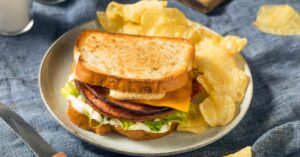 Delicious Homemade Bologna Sandwich with Lettuce, Cheese and Chips