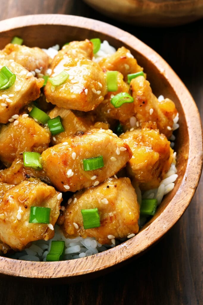 Close up of Firecracker Chicken in wooden bowl over rice