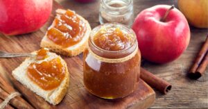 Homemade Apple Butter with Cinnamon and Bread in a Wooden Cutting Board