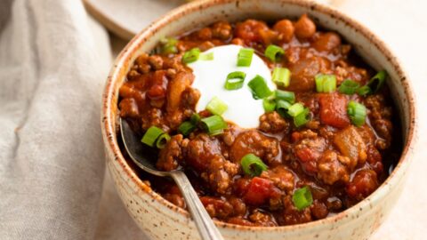 Homemade Chili with Sour Cream, Green Onions and Tomatoes in a Bowl