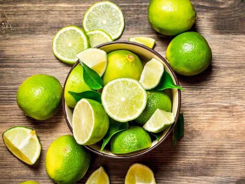 Limes Whole and Slice in a Bowl