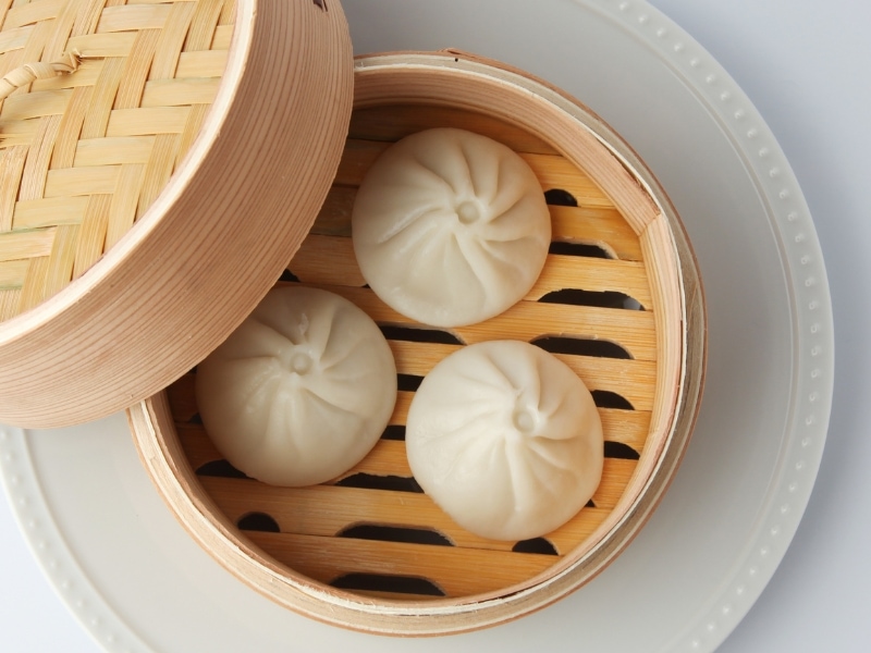 Mantou (Steamed Buns)  in a wooden Steamer on a Serving Plate 
