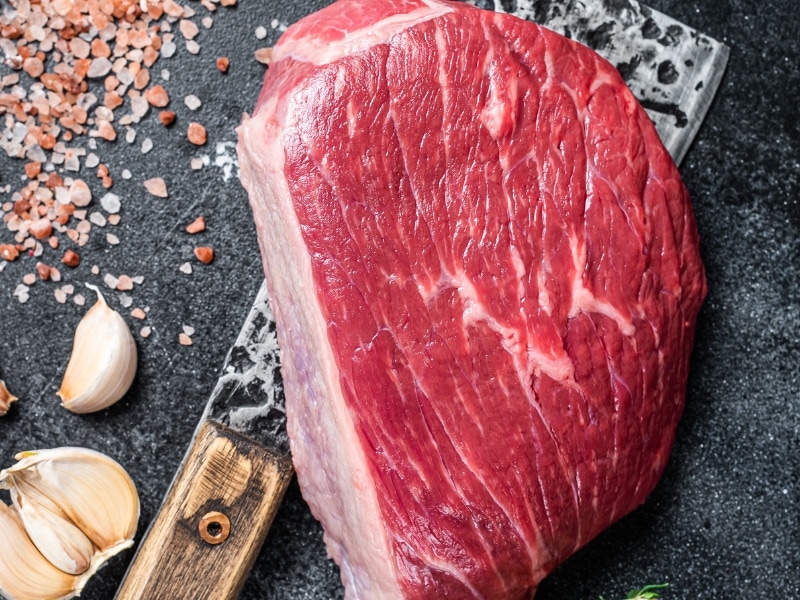 Raw Rump Steak on a Butcher Knife