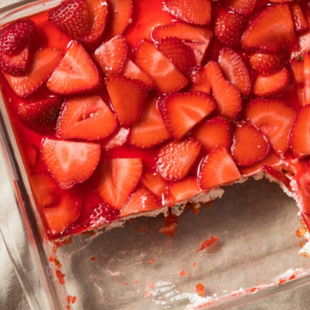 Tray of strawberry pretzel salad with piece cut out