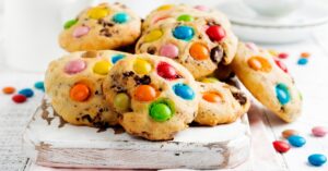 Sweet Homemade Cookies with Chocolate Candies in a Wooden Board