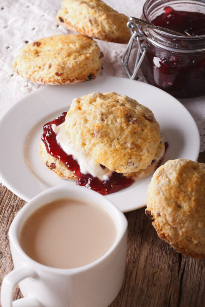 Buttermilk Scones with Red Currant Jam  on a plate beside tea with milk