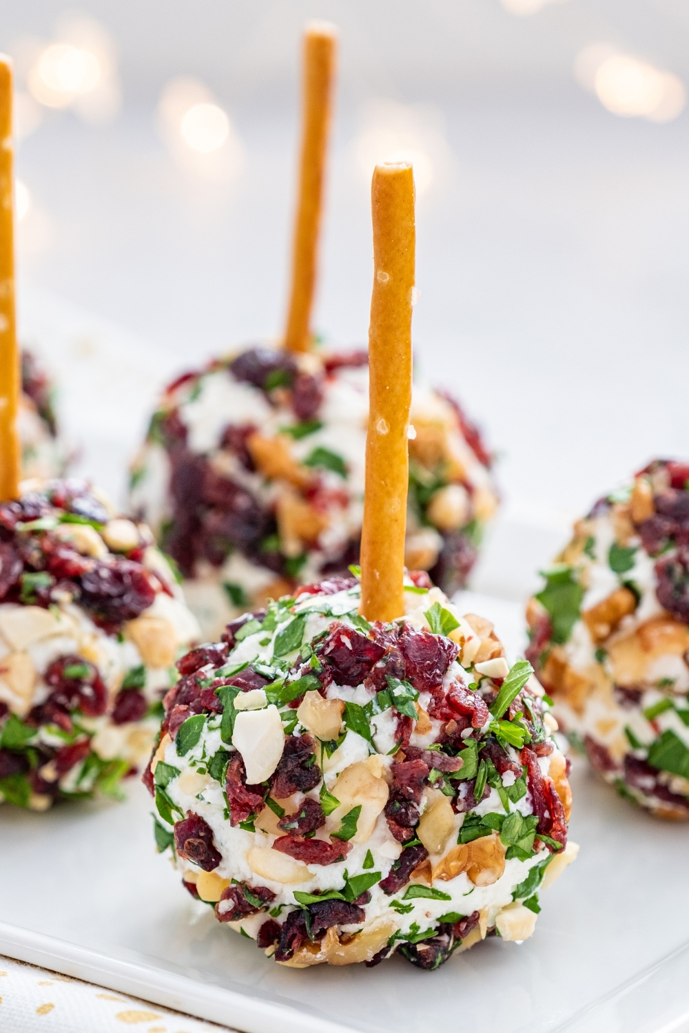 Plate of appetizing Christmas cheese balls made of cranberries, pecan and herbs