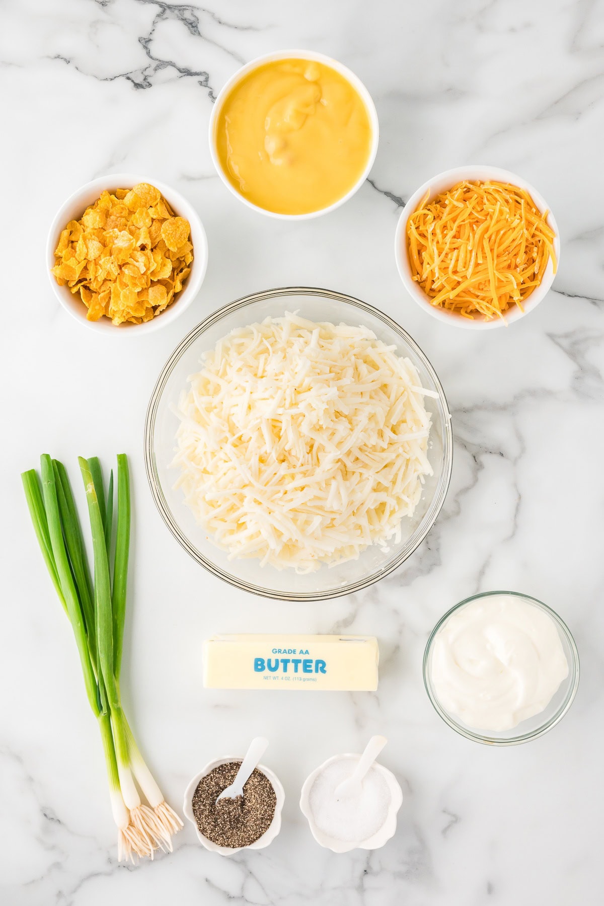 Cheesy potato casserole ingredients:  hash browns potatoes, sour creaam, green onions, cheese and butter