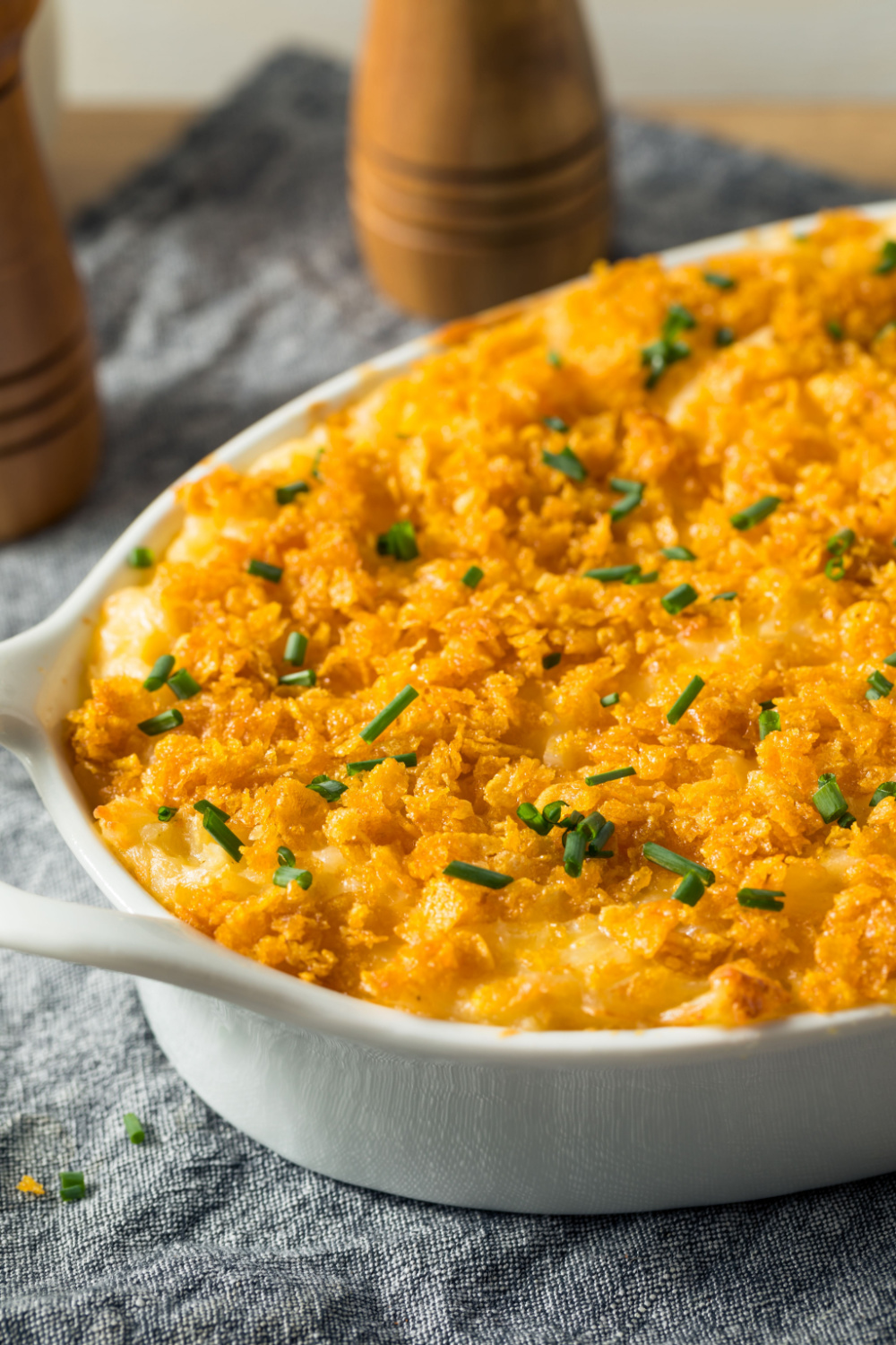 Cheesy potato casserole topped with golden brown crushed cornflakes and garnished with chopped green onions.