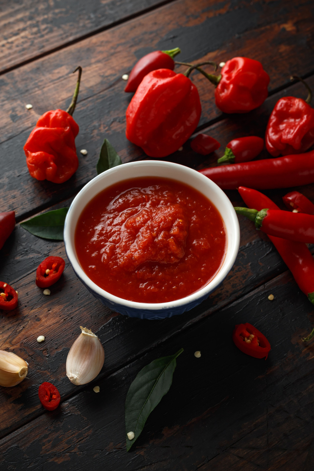 Chili Sauce and Chilis on Wooden Background