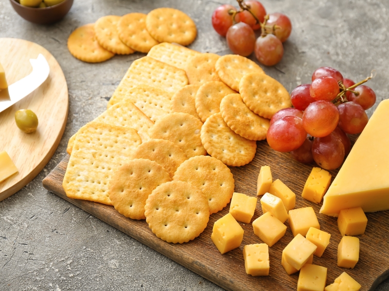 Different Crackers on a Charcuterie Board with Cheese and Grapes