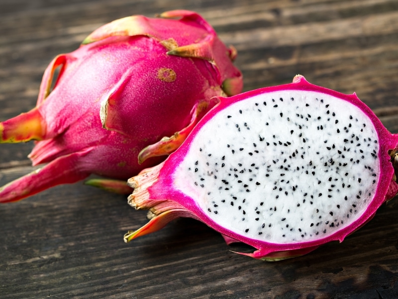 Dragon Fruit Whole and Sliced on a Wooden Table