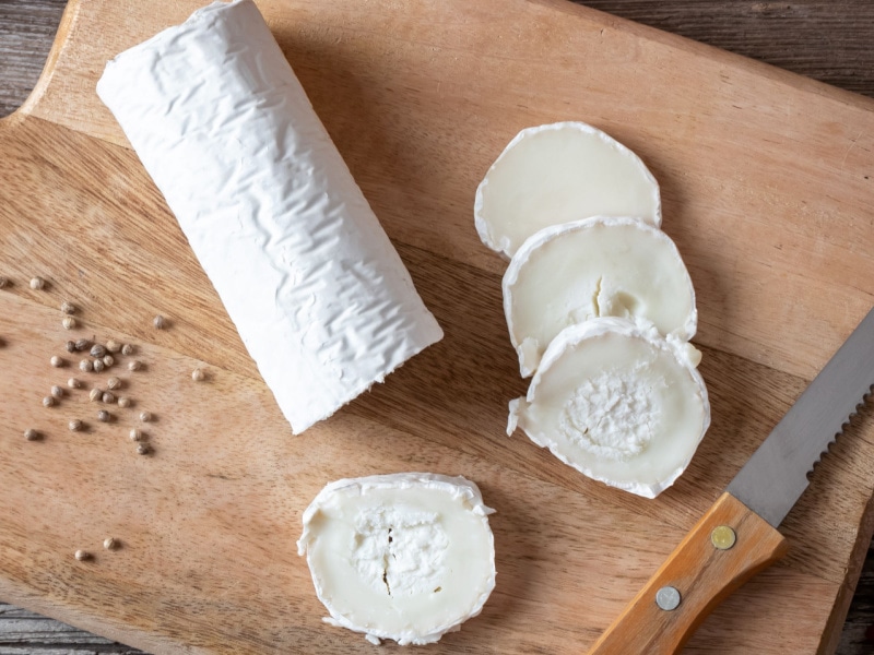 Goat Cheese Sliced on a Wooden Cutting Board