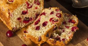 Homemade Soft and Fluffy Cranberry Orange Bread in a Wooden Cutting Board