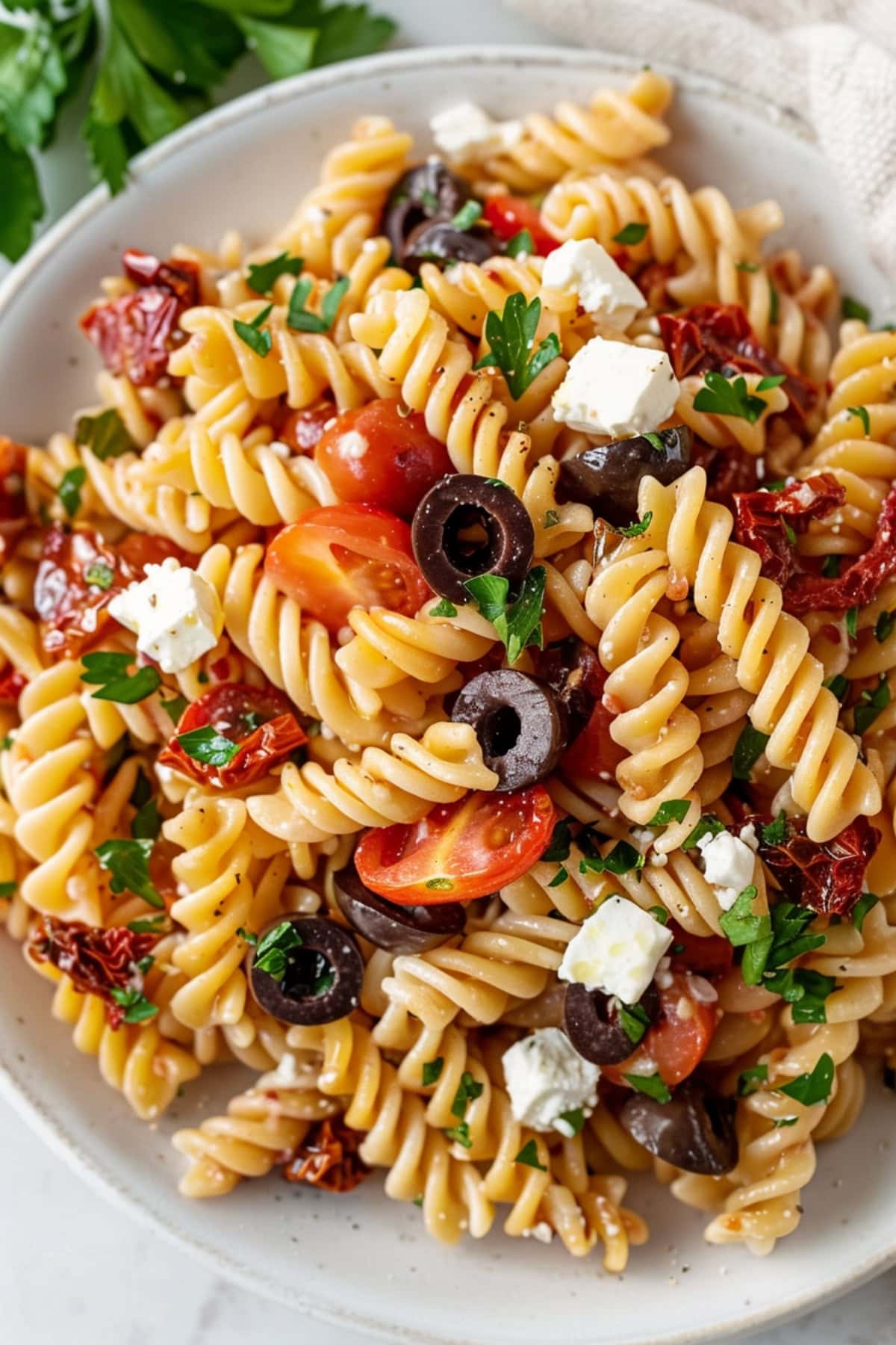 Homemade Ina Garten Pasta salad feautring fusilli, olives, tomatoes and feta.