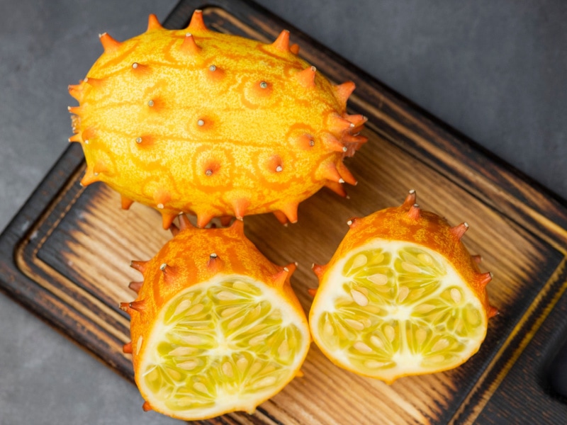 Kiwano – African Cucumbers Whole and Sliced on a Cutting Board