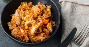 Mexican Chicken and Rice in a Black Plate with Tomato Sauce