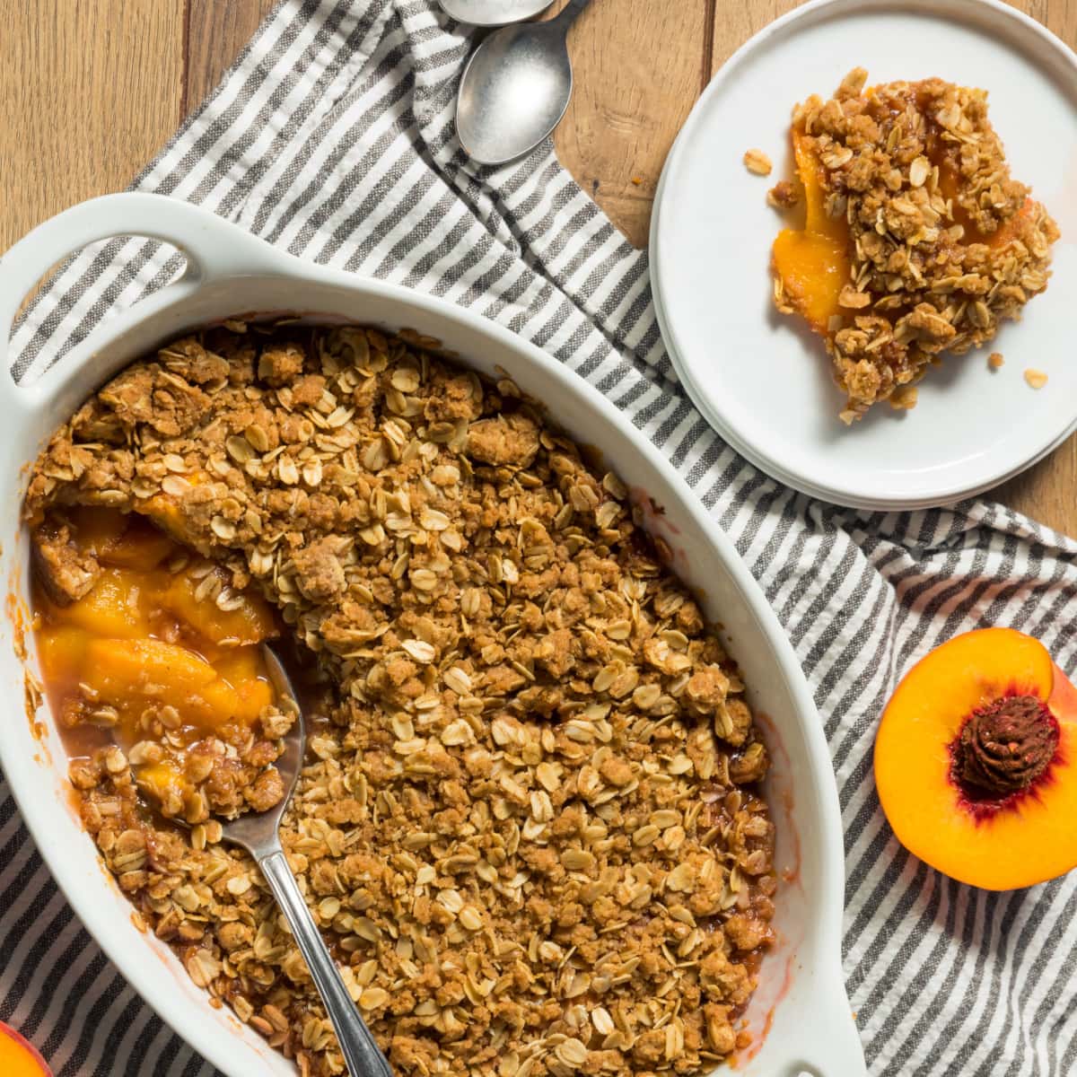 Peach crisp with a spoon, with golden-brown crust and juicy peach filling.