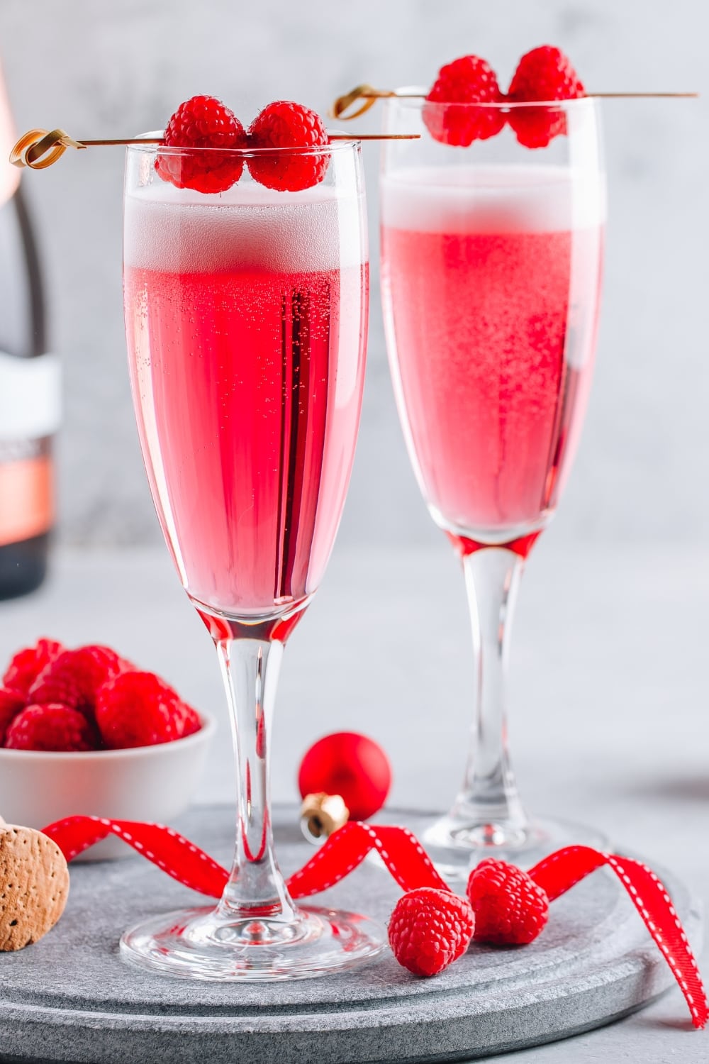 Two Glasses of Pink Raspberry Mimosa Cocktail With Fresh Berries 