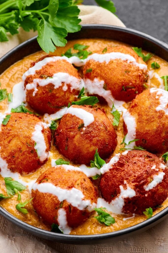 Potato and Cheese Deep Fried Balls in Tomato Gravy with Spices