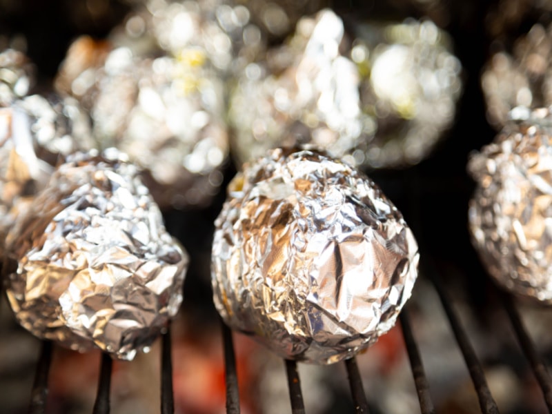 Baked Potatoes Wrapped in Foil on Grill